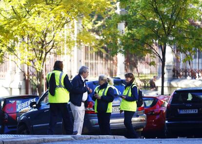 Trabajadores del Servicio de Estacionamiento Regulado SER informan a un conductor de las restricciones en el paseo de Reina Cristina.