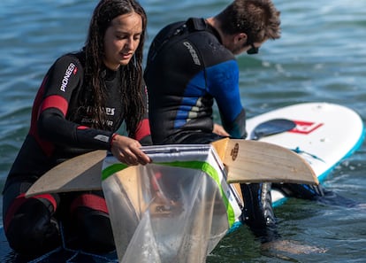 Voluntarios recogen plásticos en la playa de Barcelona para el proyecto Surfing for Science.