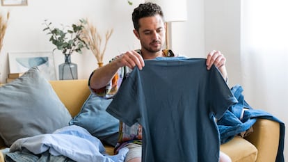 Chico doblando la ropa limpia en su casa.