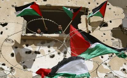 Dos jóvenes ondean banderas palestinas en Rafah (Gaza) en una protesta para pedir a Egipto que suministre electricidad y combustible a la Franja.