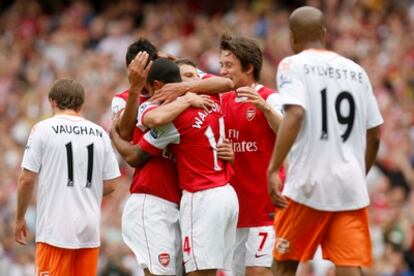 Dos jugadores del Blackpool vuelven hacia el centro del campo después de un gol del Arsenal en un encuentro de la Premier League de este año.