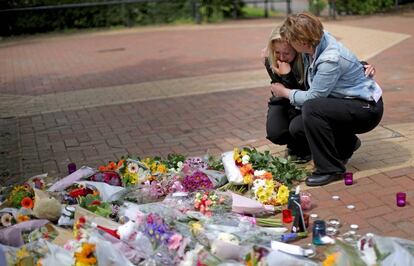 Dues dones deixen flors a Tarleton, on vivia una de les víctimes mortals de l'atemptat de Manchester, aquest dimecres.