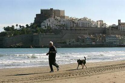 Un paseante en la playa Norte de Peñíscola (Castellón).