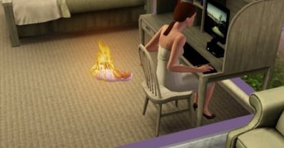 Mem creat a partir d’una captura del videojoc Sims. Un nadó crema en flames mentre la mare fa ‘scroll’ a la pantalla de l’ordinador