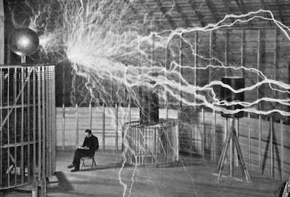 Nikola Tesla toma notas durante uno de sus experimentos.