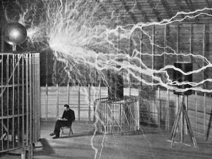 Nikola Tesla toma notas durante uno de sus experimentos.