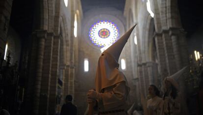 Penitentes encapuchados de hermandad La Borriquita participan en una procesión de Semana Santa en Córdoba.