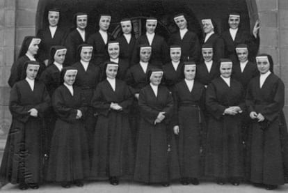 Orphanage head Sister Juana is wearing glasses, standing fifth to the right in the second row. Mercedes is resting her hand on the wall.