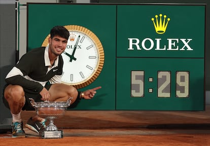 El español Carlos Alcaraz señala el reloj de la pista Philippe Chatrier, en París, con la duración de la final de Roland Garros 2025