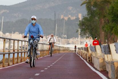 Varios ciclistas practican deporte por el paseo marítimo de Palma de Mallorca. 