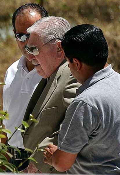 Pinochet, escoltado por dos guardaespaldas en su residencia.