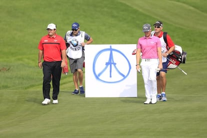Patrick Reed y Kristoffer Broberg llevan una pancarta con la Torre Eiffel y el símbolo de la paz en el BMW Masters de Shangai 