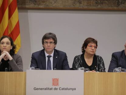 El president de la Generalitat, Carles Puigdemont, entre l'alcaldessa de Barcelona i els consellers de Treball i d'Empresa.