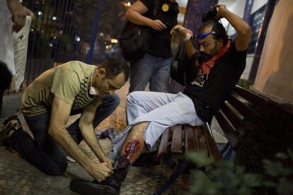 Un hombre es atendido de sus heridas durante los enfrentamientos con la policía cerca del palacio de Guanabara en Río de Janeiro, 22 de julio de 2013.
