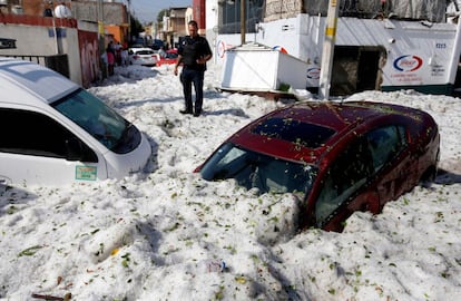 Embora as chuvas de granizo sejam usuais nesta estação do ano, não há registro de uma tão forte quanto neste domingo. Na imagem, um policial ao lado de vários veículos enterrados pelo granizo na cidade de Guadalajara (México).