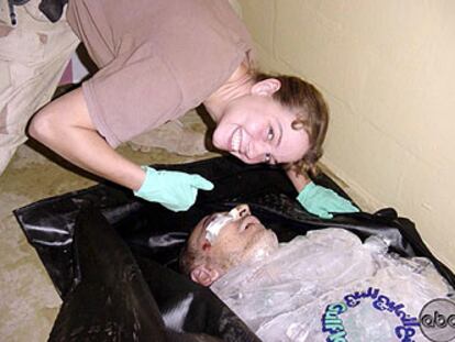 La soldado Sabrina Harman sonríe junto al cadáver de un preso iraquí en la prisión de Abu Ghraib.