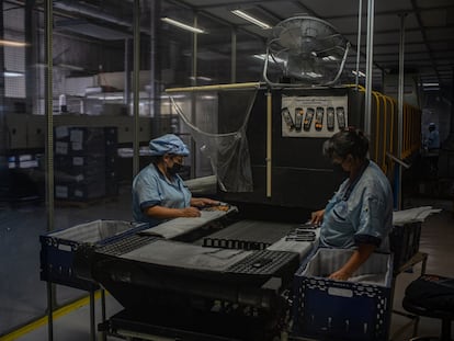 Dos mujeres trabajan en la fabricación de controles remotos para la televisión, en Tijuana, en 2021.