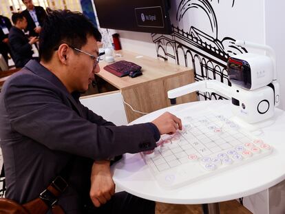 Un hombre enfrentándose a un robot en una partida de Go, un juego de mesa tradicional chino.