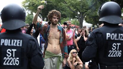 Homem segura uma flor durante manifestação contra as medidas de combate a coronavírus, neste sábado, em Berlim.