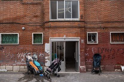 Varios carritos de bebé permanecen aparcados a la puerta de uno de los portales.