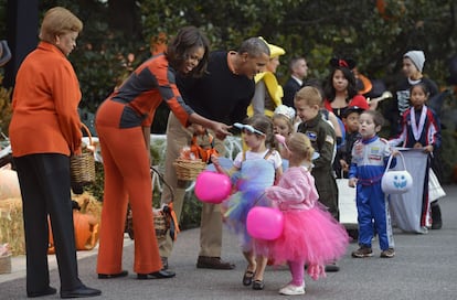 El presidente estadounidense Barack Obama y la primera dama, Michelle Obama y su madre, Marian Robinson, le dan la bienvenida a un grupo de niños disfrazados en la Casa Blanca en Washington.