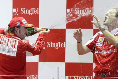 Aldo Costa con Fernando Alonso en el podium del GP de Singapur de 2010.