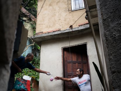 Voluntário entrega sabonete para um morador da favela da Rocinha, Rio de Janeiro, no dia 24 de março.