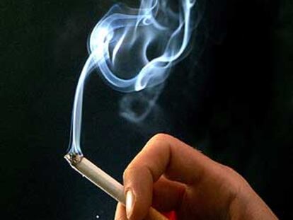 Una mujer sostiene un cigarrillo.