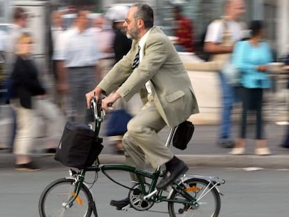 Um homem anda de bicicleta em Paris (França).