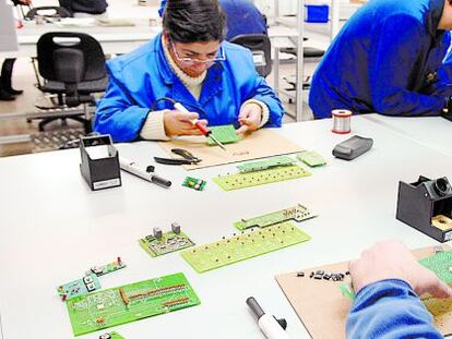 Trabajadores con discapacidad ps&iacute;quica en un taller de electr&oacute;nica. 