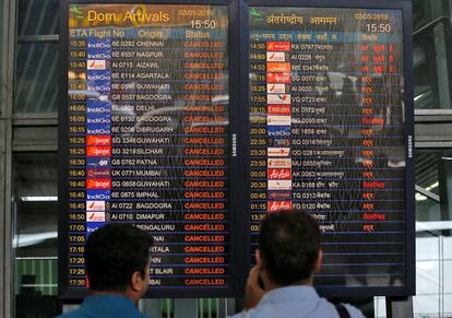 Pasajeros varados consultan en una pantalla información de vuelos cancelados después del paso del ciclón Fani, en el Aeropuerto Internacional Netaji Subhas Chandra Bose en Calcuta (India). 
