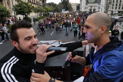 Dos de los miembros de Aspencat amenizan con <i>raps</i> un tramo de la cabalgata por la enseñanza en valenciano.