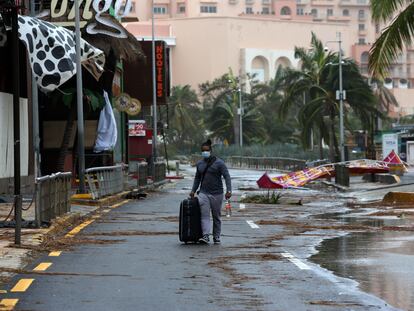 Un turista camina entre los escombros ocasionados por el huracán Delta en Cancún, este miércoles.
