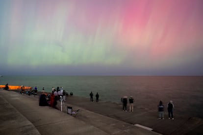 Personas admiran las auroras boreales desde Montrose Point, el jueves 10 de octubre, en Chicago (Illinois).