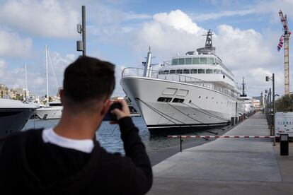 Un turista toma fotografías de un superyate atracado en el Port Vell.
