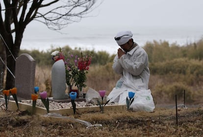 Norio Kimura resa davant d'un monument que va construir per recordar la seva família morta pel terratrèmol.