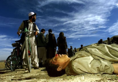 Un grupo de personas observan el cadáver de un combatiente talibán a tres kilómetros al norte de Kabul, el 13 de noviembre de 2001, el día de la toma de la capital afgana por parte de la coalición.