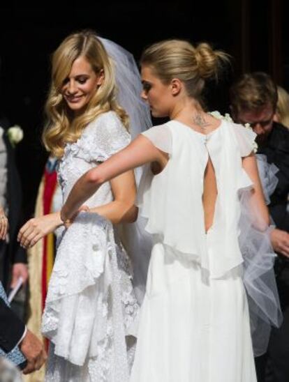 Cara colocándole la cola del vestido a su hermana Poppy.