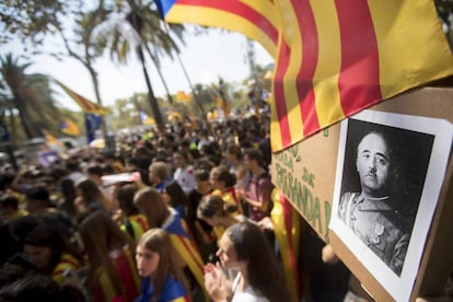 Hundreds of people congregate at a courthouse in Barcelona, and one person holds up a photo of Franco.