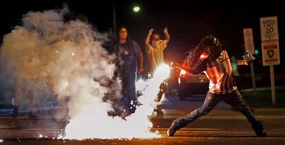 A equipe de fotografia do 'St. Louis Dispatch' venceu na categoria Notícias Urgentes. Na imagem, um manifestante atira um sinalizador contra policiais, durante os protestos de 13 de agosto de 2014 em Ferguson (Missouri, EUA).