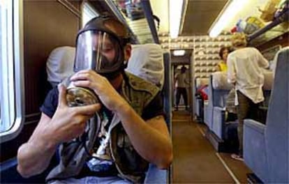 Un activista antiglobalización se prueba una máscara antigas en un tren de Roma a Génova, donde han sido convocadas manifestaciones contra el G-8.