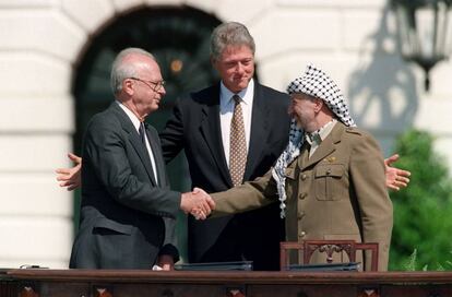 Isaac Rabin y Yasir Arafat estrechan sus manos en presencia de Bill Clinton.