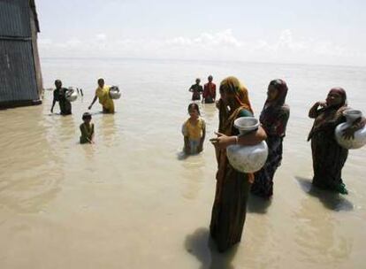 Mujeres y niños en el río Jamuna, en Bangladesh, desbordado tras las lluvias.