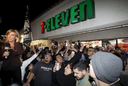 Una muchedumbre se concentra ante la puerta del 7 Eleven que vendió el boleto premiado.
