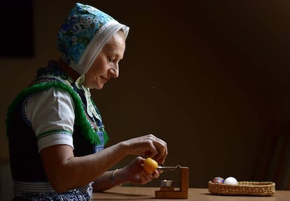 Una mujer de la minoria sorbia decora un tradicinal huevo de Pascua en Schleife (Alemania), el 18 de abril de 2019.