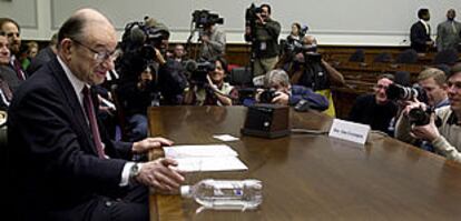 Greenspan coloca en posición horizontal una botella de agua para facilitar el trabajo de los fotógrafos, ayer, durante su comparecencia en el Congreso.