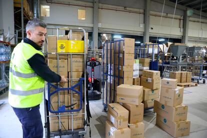 Un trabajador de Planeta Huerto mueve un carro lleno de pedidos de hasta 15 kilos que Correos enviará a algún lugar de España.