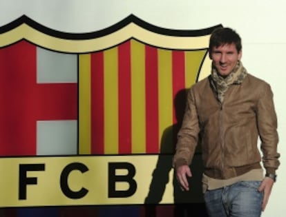 Messi posa junto a un escudo del Barça.