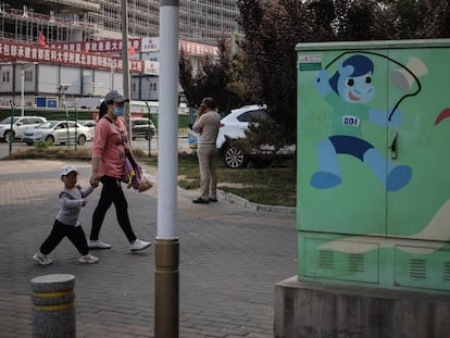 Una mujer y un niño caminan por una calle de Pekín este miércoles