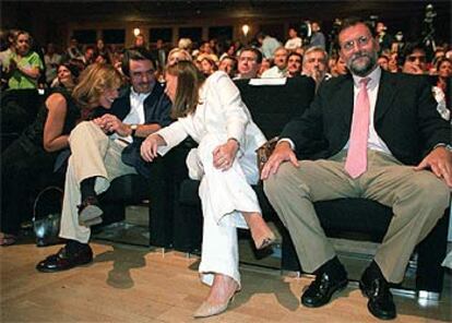 José María Aznar y Mariano Rajoy, con sus respectivas esposas, ayer, en el mitin del PP en Madrid.